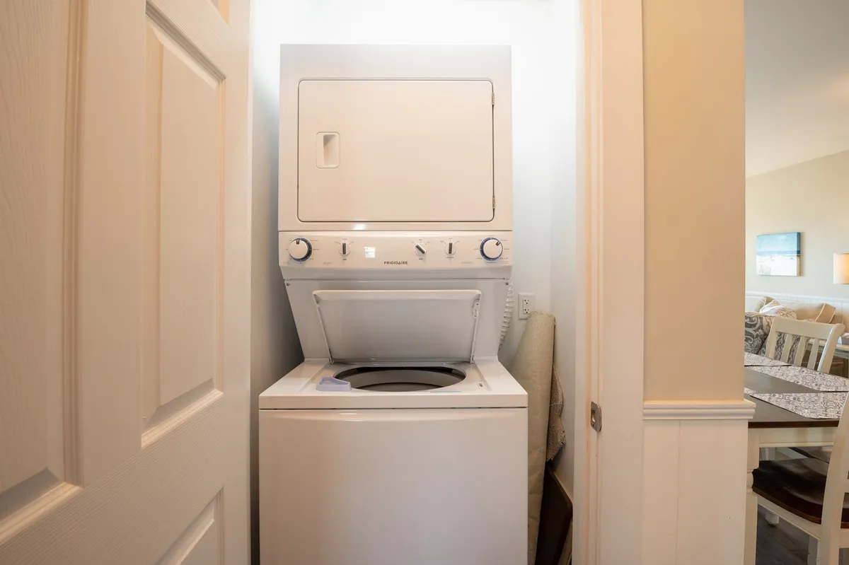 A neatly stacked washer and dryer are conveniently located inside the home, visible through a doorway that leads to the living area. The space is organized and functional, making laundry tasks easy for guests.
